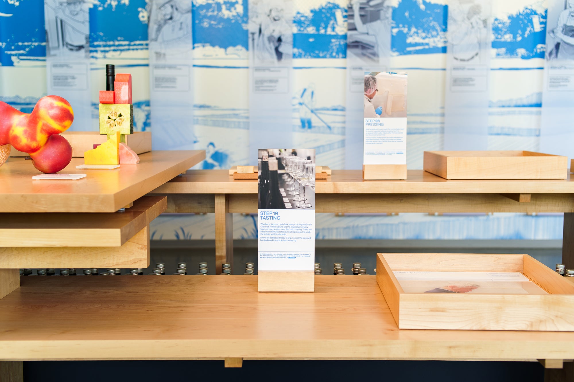Display tables with various items in front of a blue and white wall